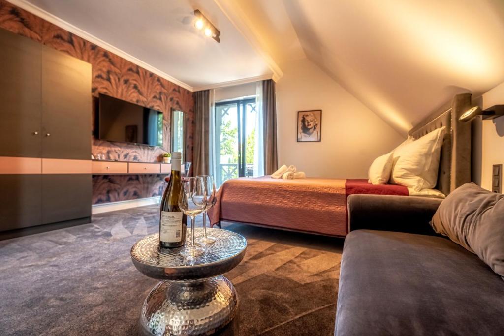 Habitación con 2 camas y una botella de vino en una mesa en Villa Viktória, en Balatonfüred