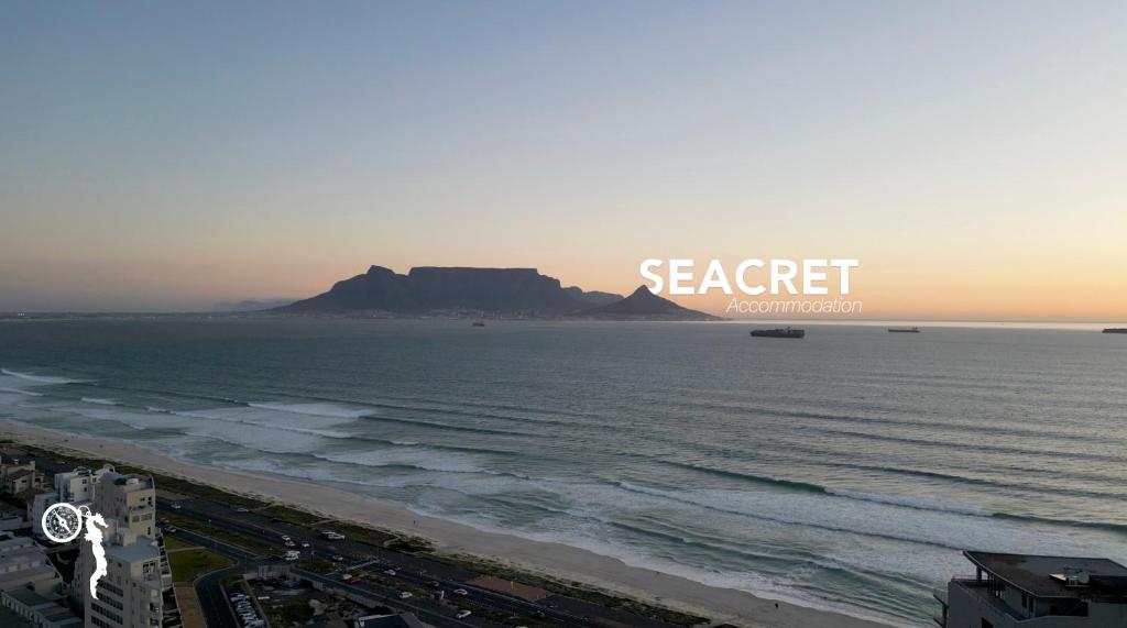 a view of a beach with a mountain in the background at Seacret Whale in Bloubergstrand