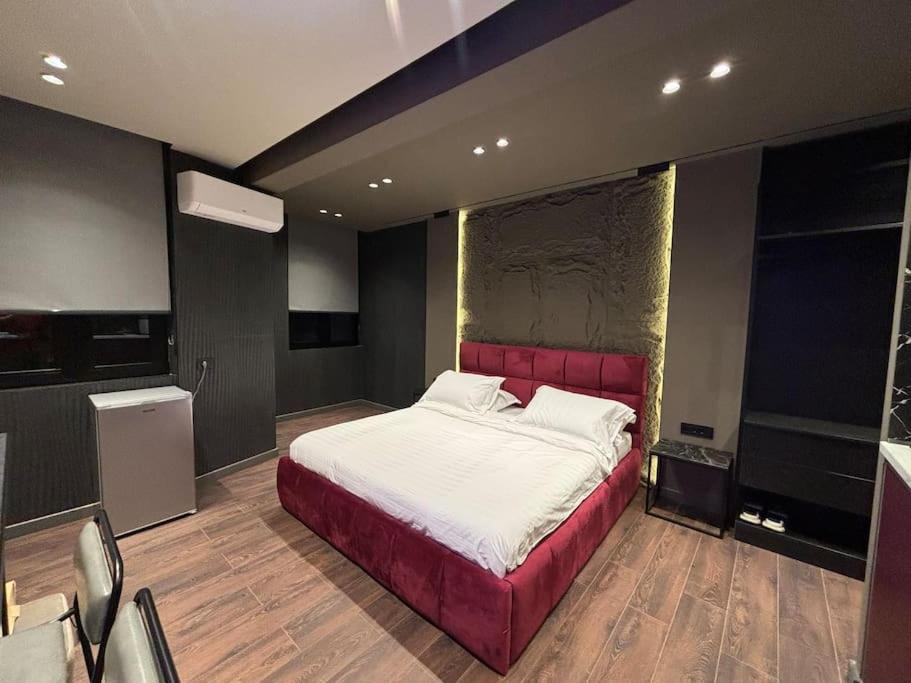 - une chambre avec un grand lit et une tête de lit rouge dans l'établissement Luxury Boutique Apartments (red) City Center, à Tirana