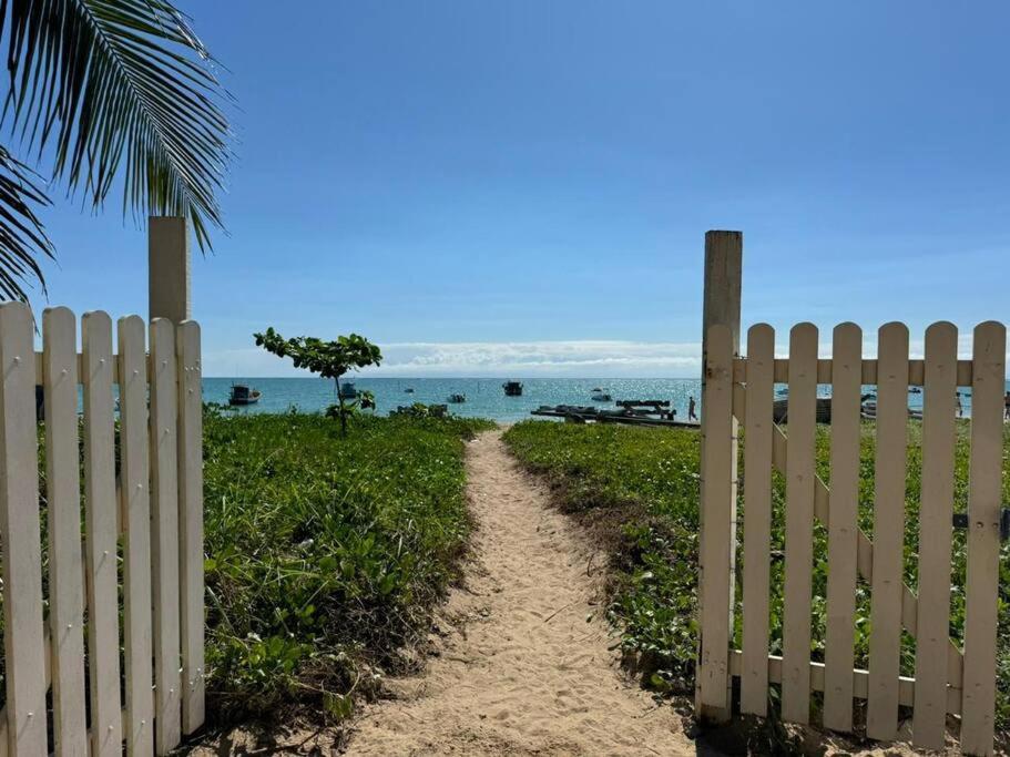 einen Zaun neben einer unbefestigten Straße neben dem Strand in der Unterkunft Casa Pê na Areia e Vista ao Mar em São José in São José da Coroa Grande