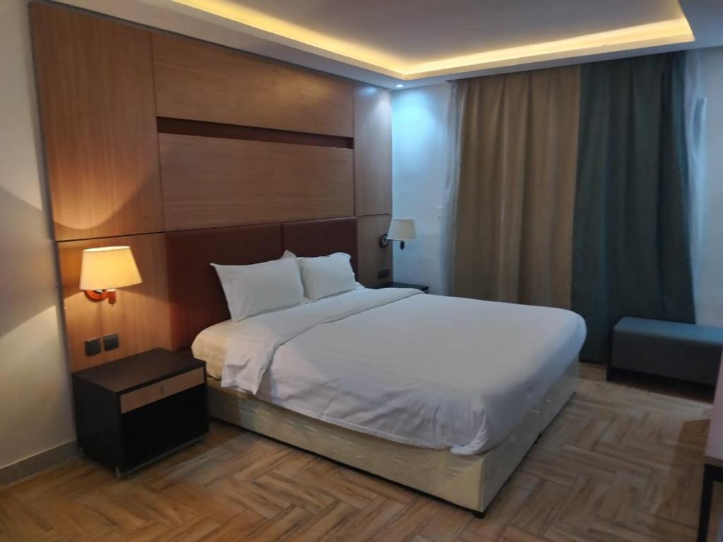 - une chambre avec un grand lit blanc et une chaise dans l'établissement سما ستار للشهري والسنوي, à Djeddah