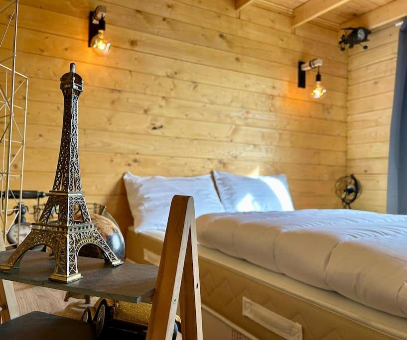 ein Schlafzimmer mit einem Bett und einem Tisch mit einem Eiffelturm in der Unterkunft Les Chalets du Parc 