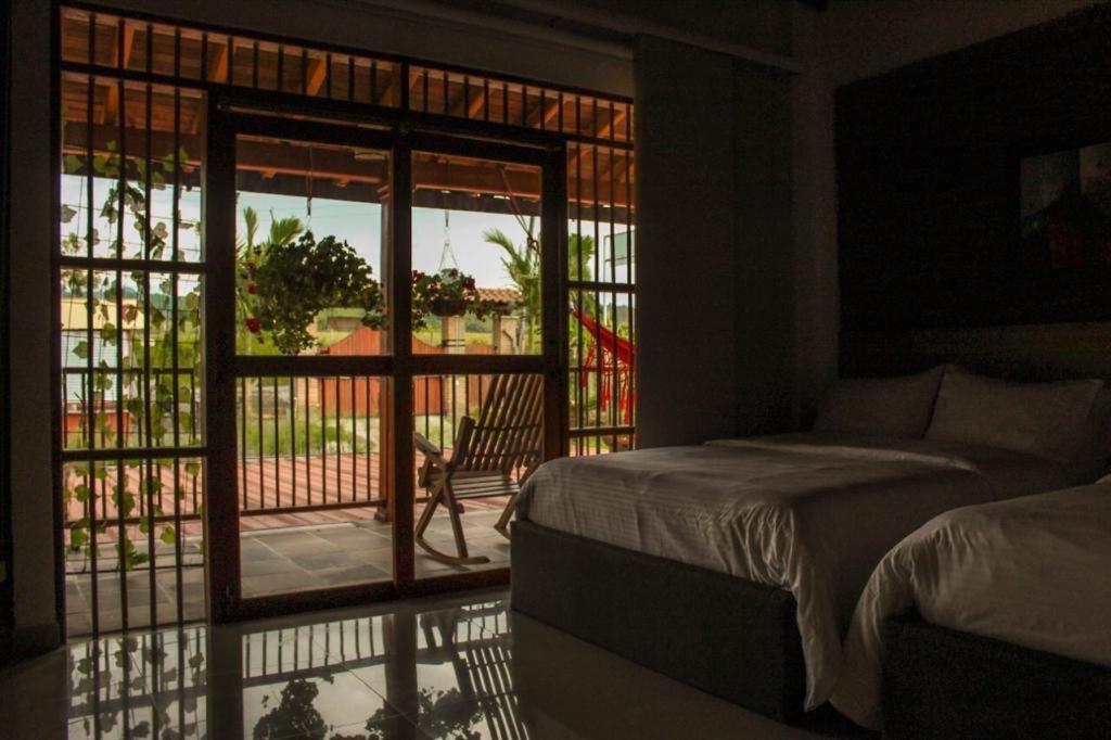 1 dormitorio con 1 cama y balcón con vistas. en Santa bárbara en Santa Rosa de Cabal