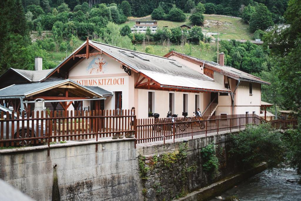 un edificio sobre un puente sobre un río en Gasthaus Kitzloch, en Taxenbach