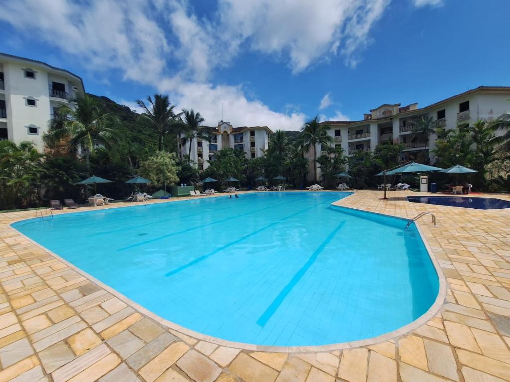 a large swimming pool in a resort at PARAÍSO Ubatuba - Praia Grande-Toninhas - Apartamento Cond Wembley Tenis in Ubatuba
