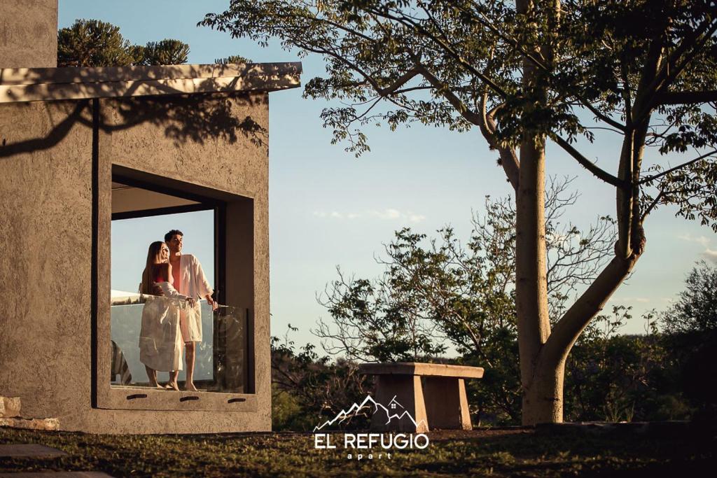 een bruid en bruidegom staan in een raam bij El Refugio Apart in Villa Serranita