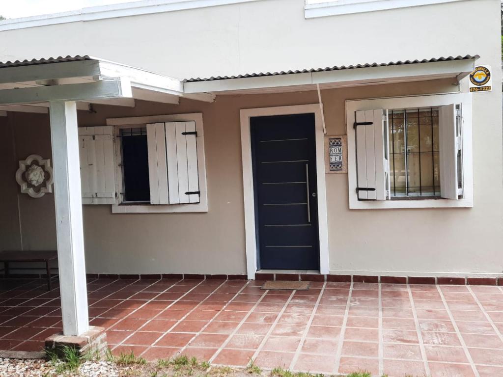 een wit huis met een blauwe deur en ramen bij ROMFER in San Eduardo del Mar