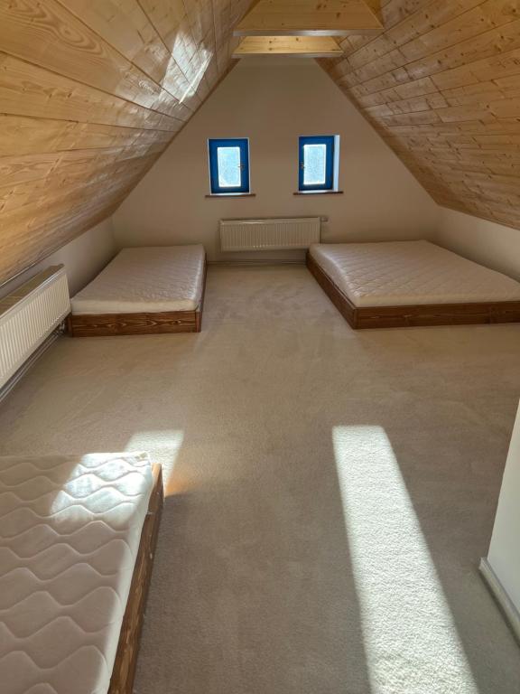 Cette chambre mansardée comprend 2 lits et 2 fenêtres. dans l'établissement ŠTAJNHAUS DUBICE, 