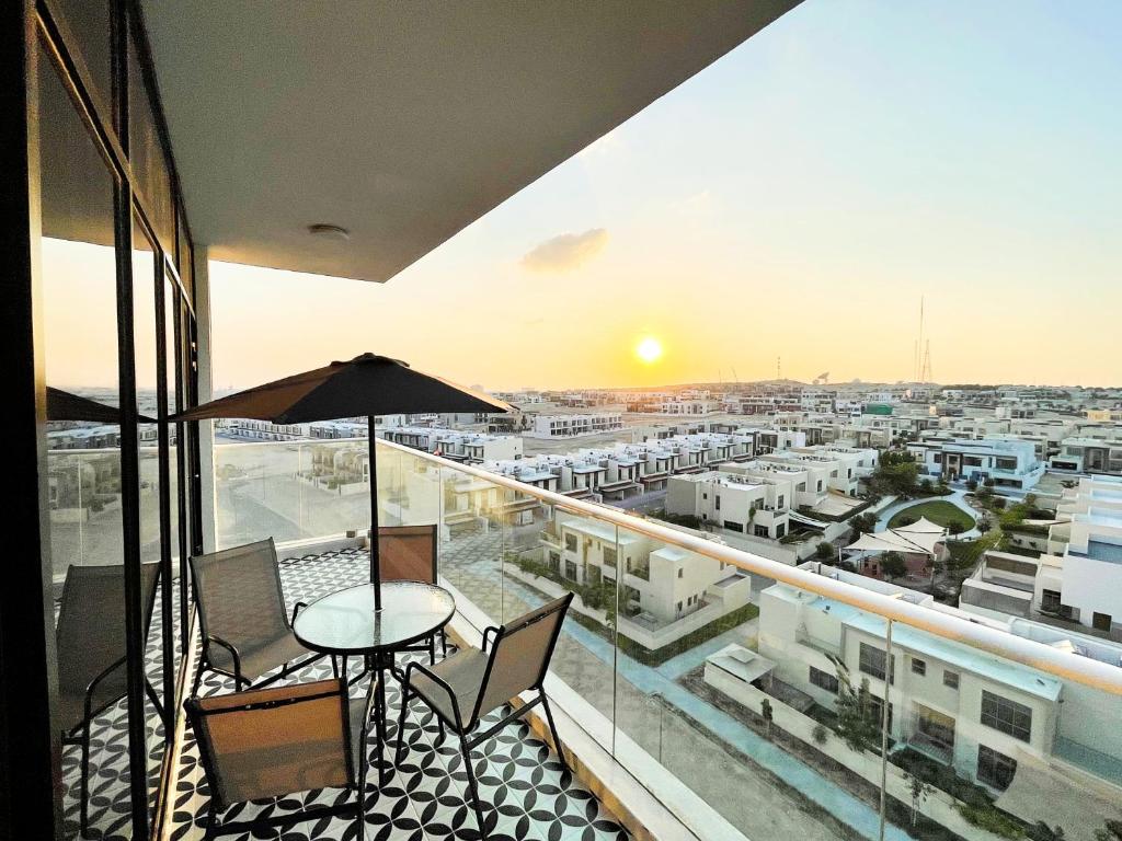 a balcony with a table and chairs and a view of a city at Cozy apartment with Pool - 10 mins from Dubai Marina in Dubai