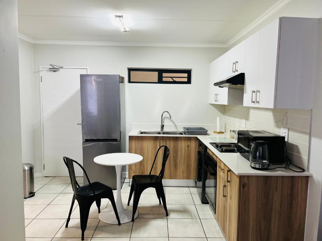 a kitchen with a table and chairs and a sink at Lethabo Eco_Estate in Boksburg