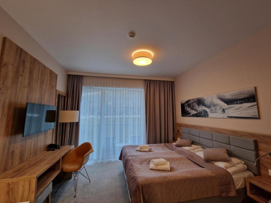 Habitación de hotel con cama grande y TV en Aparthotel Czarna Góra 239 en Sienna
