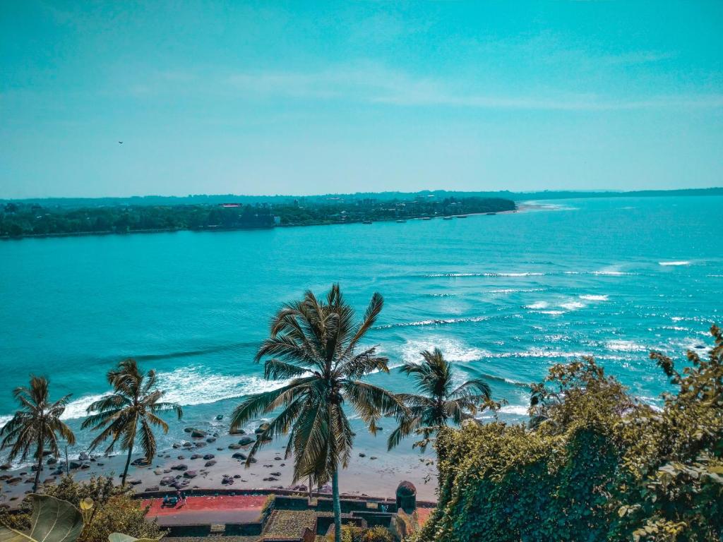 a view of a beach with palm trees and the ocean at sea shore guest house morjim beach in Morjim