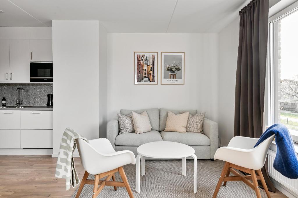 sala de estar blanca con sofá y sillas en Stylish Urban Home in Stockholm, en Estocolmo