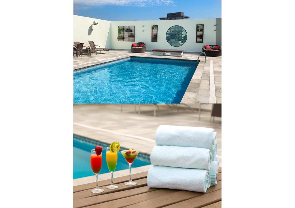 a pool with two cocktails and a stack of towels at Leques Brasil Hotel Escola in Sao Paulo