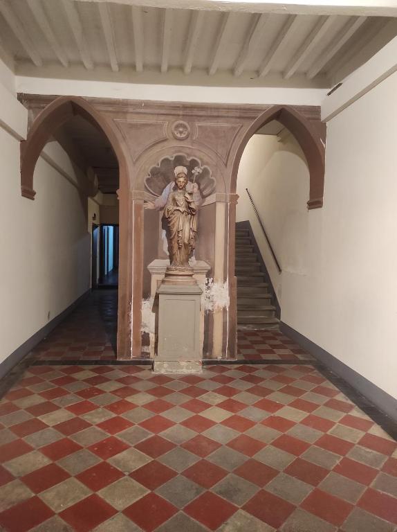 une statue d'un ange sur un piédestal dans un couloir dans l'établissement La Casina, à Arezzo
