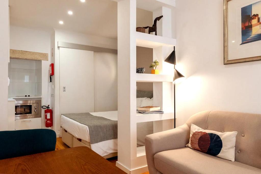 ein kleines Wohnzimmer mit einem Bett und einem Sofa in der Unterkunft Martin Vaz Home Design in Lissabon