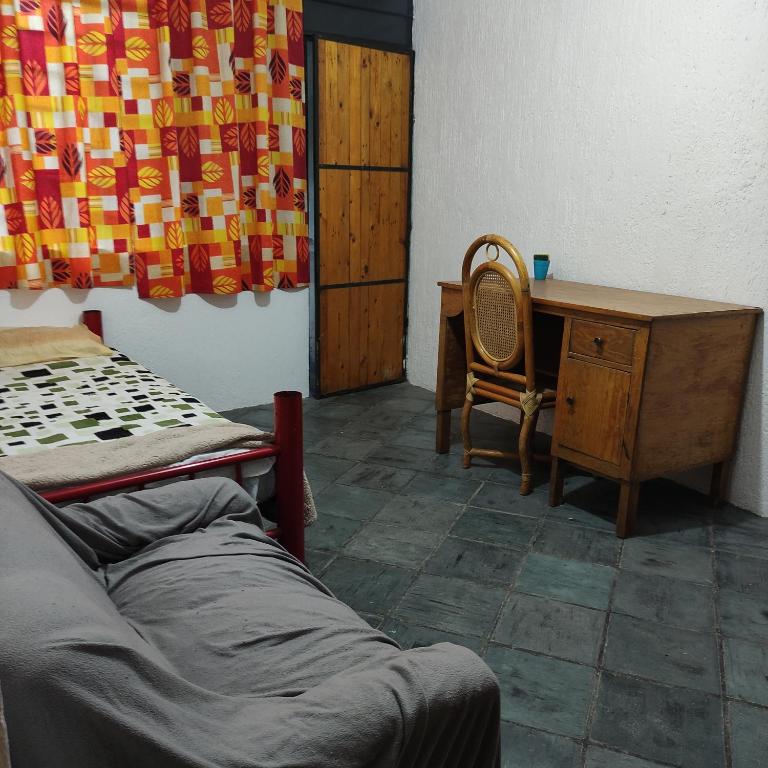 um quarto com uma secretária, uma cama e uma cadeira em Casa ampliación piloto em Cidade do México