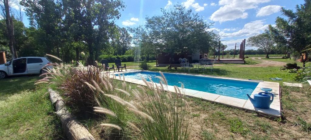 a car parked next to a swimming pool in a yard at La Cabañita in Colonia Caroya