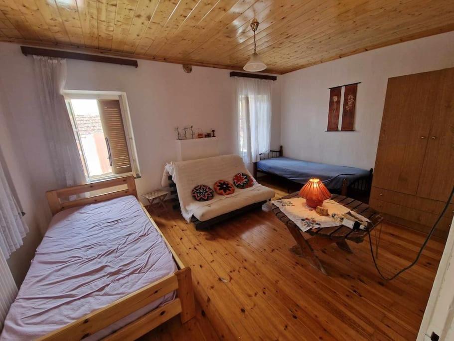 Habitación con 2 camas, sofá y mesa. en Σπίτι στο χωριό, en Filýra