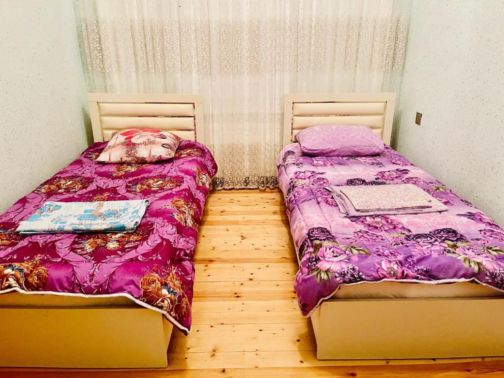 two beds sitting next to each other in a room at AkbA-Frame1 in İsmayıllı