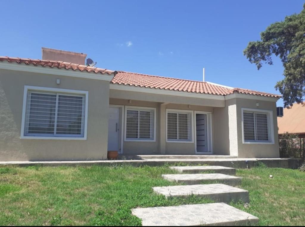 ein Haus mit einem Weg davor in der Unterkunft Departamentos Vila in Mina Clavero