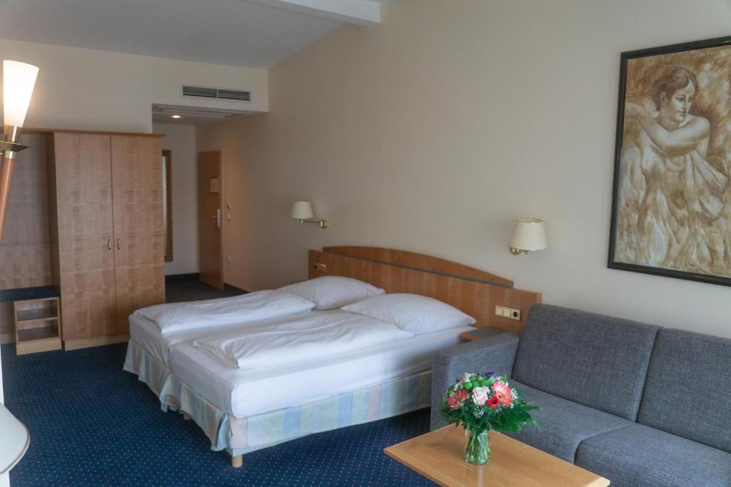 a hotel room with a bed and a couch at Hotel Daniel in Munich