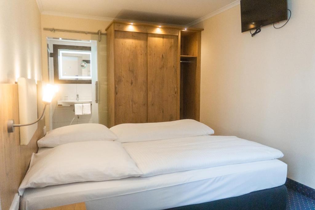a room with two beds and a television in it at Hotel Daniel in Munich