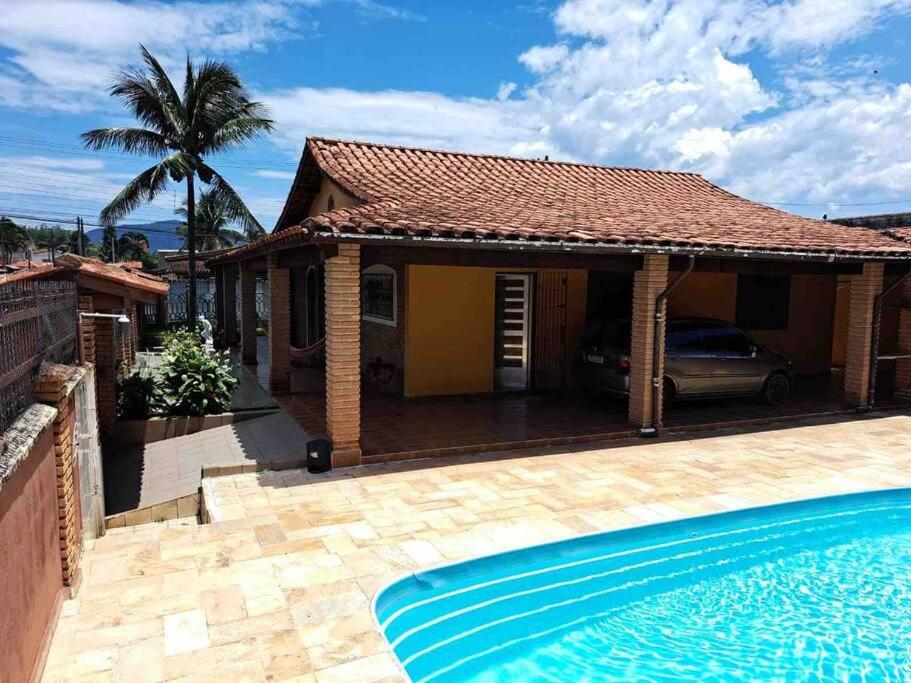 a house with a swimming pool in front of a house at Maravilhosa Casa a 20 Metros da PRAIA in Caraguatatuba