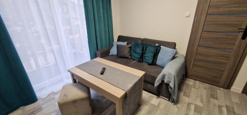 ein Wohnzimmer mit Sofa und Tisch in der Unterkunft Angel in Kołobrzeg