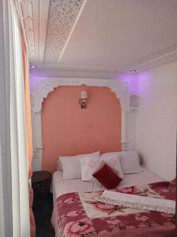 1 dormitorio con 1 cama con luz morada en Studio Amine avec une terasse privée en Rabat