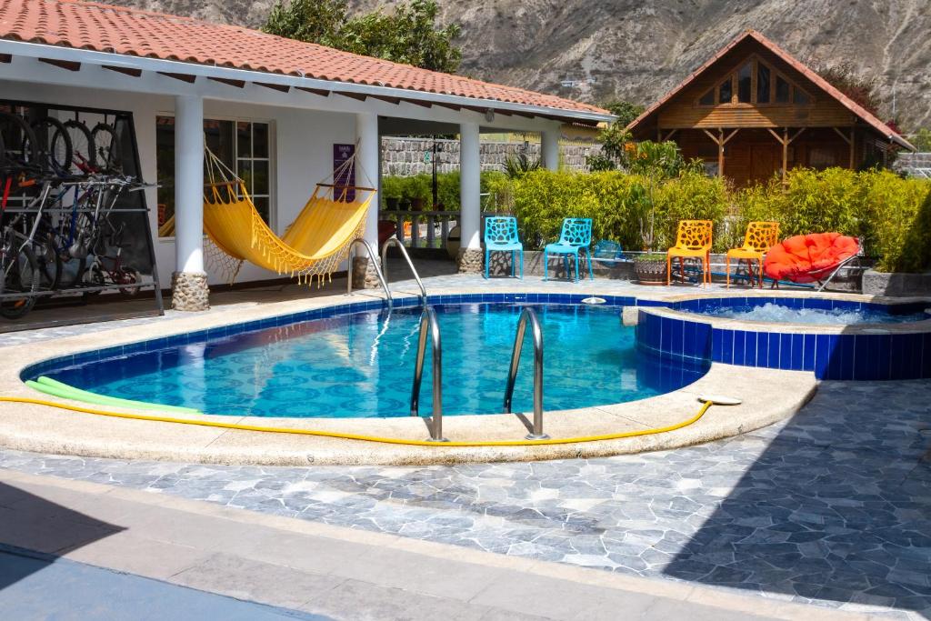uma piscina com escorrega e cadeiras e uma casa em La Casita de chocolate em Quito