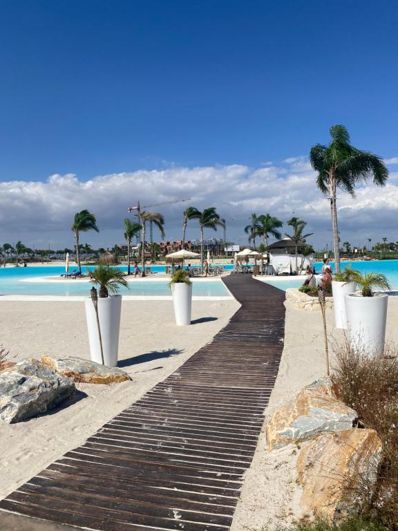 eine Promenade am Strand mit Palmen und einem Pool in der Unterkunft Casa Rosalia Laguna in Torre-Pacheco
