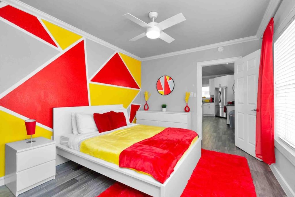 - une chambre avec un mur rouge jaune et blanc dans l'établissement Prolific Red Luxe: Private Deck + Stylish Living, à Houston