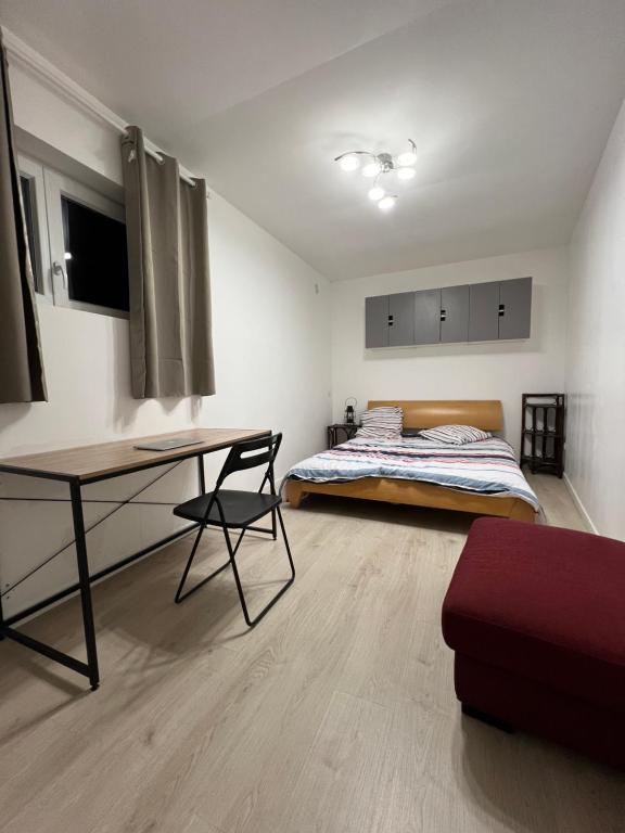een slaapkamer met een bed, een bureau en een tafel bij Studio indépendant plein pied avec mezzanine in Joinville-le-Pont