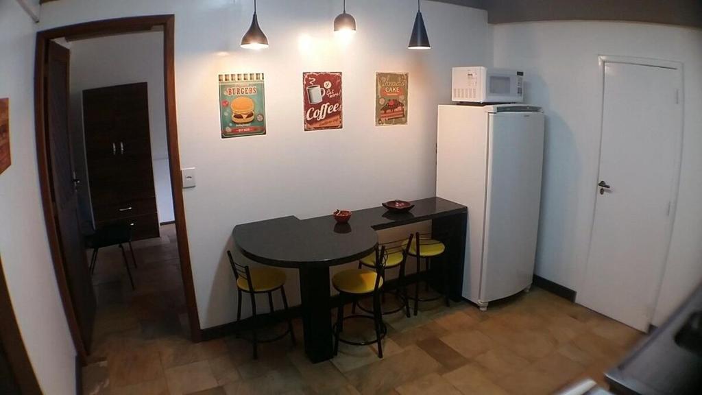 uma pequena cozinha com uma mesa e um frigorífico em AP3 - 1dorm privado próx Garten Shop-Universidades em Joinville