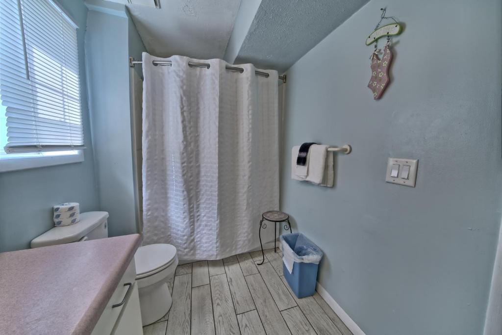 a bathroom with a shower curtain and a toilet at Pineapple Villas in Panama City Beach