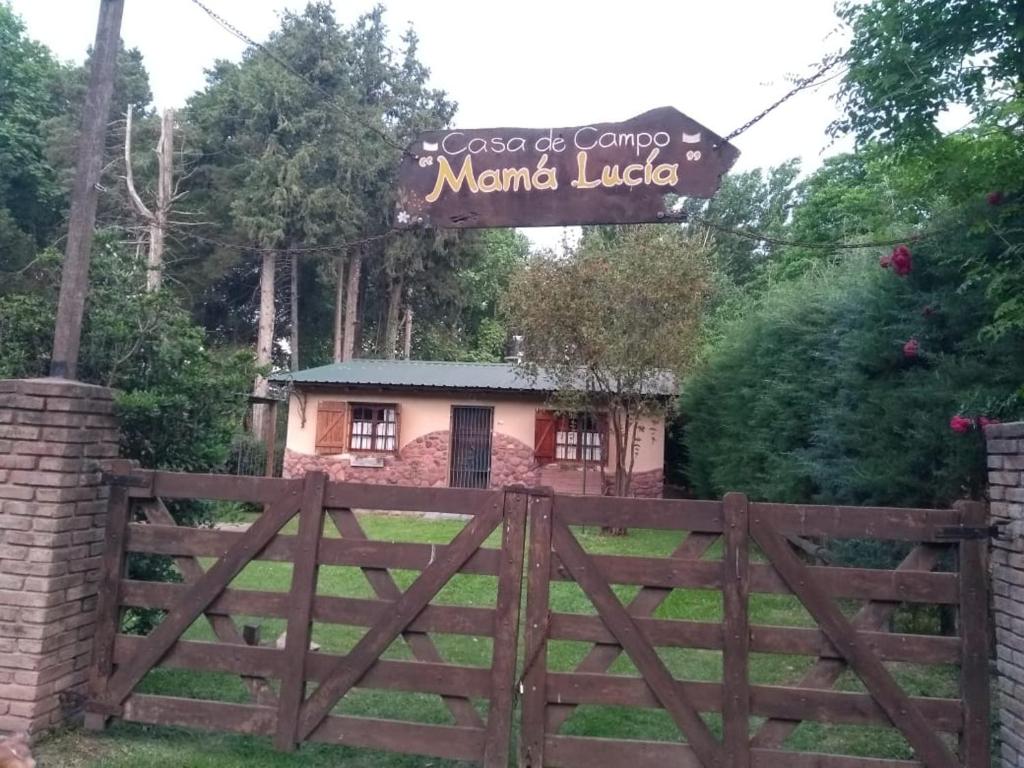 ein Zaun vor einem Haus mit einem Schild in der Unterkunft Casa de Campo Mama Lucia in Villa Anizacate