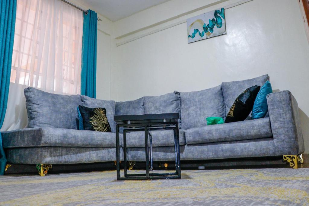 a living room with a blue couch and a table at J&J luxury homes in Kericho