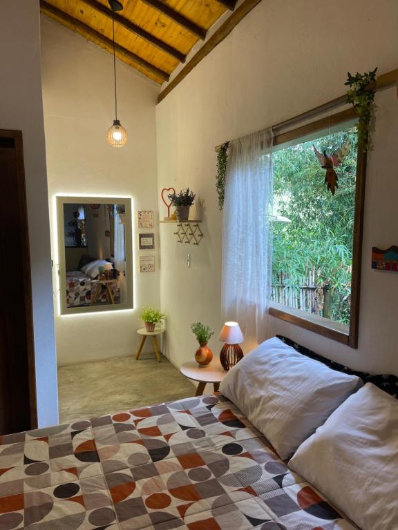 sypialnia z łóżkiem i dużym oknem w obiekcie Chale Pepe w mieście Carrancas