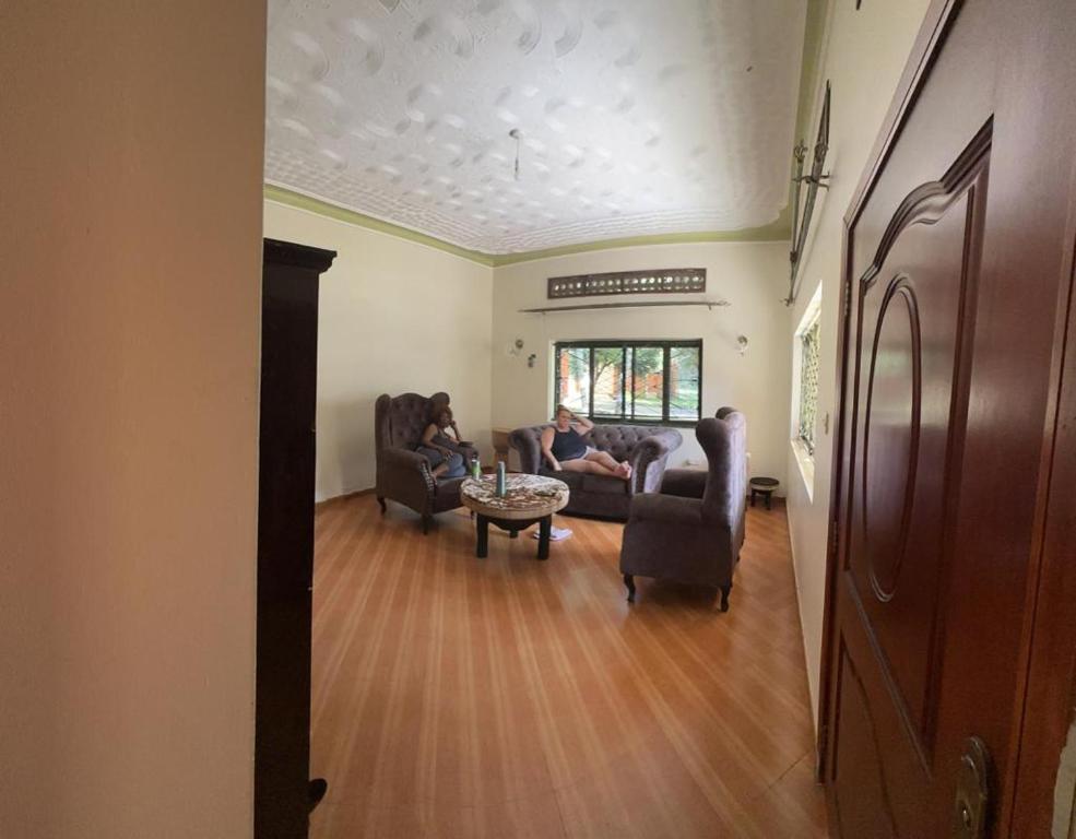a living room with two people sitting on couches at Lido Azzurro Garuga in Wakiso