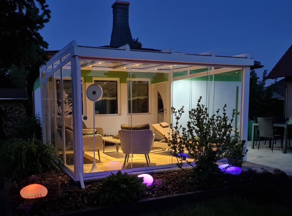 a gazebo with glass walls and a patio at Ferienhaus Grüner Bungalow & Whirlpool in Stendell
