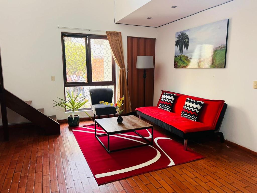 a living room with a red couch and a red rug at Duplex en primer piso - A media Cuadra Embajada USA in Lima