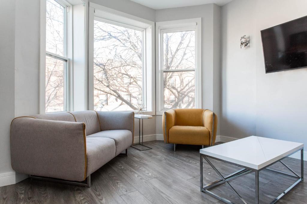 a living room with a couch and a chair at Prime Location! - 1min Walk to Wrigley Field - Modern 2BR Apts Right Next to Wrigley Field & Transit! in Chicago