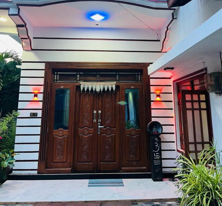 dom z dużymi drewnianymi drzwiami przed nim w obiekcie Navai Guest House w mieście Kallady