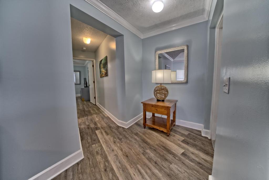 a hallway with blue walls and a table with a lamp at Pineapple Villas in Panama City Beach