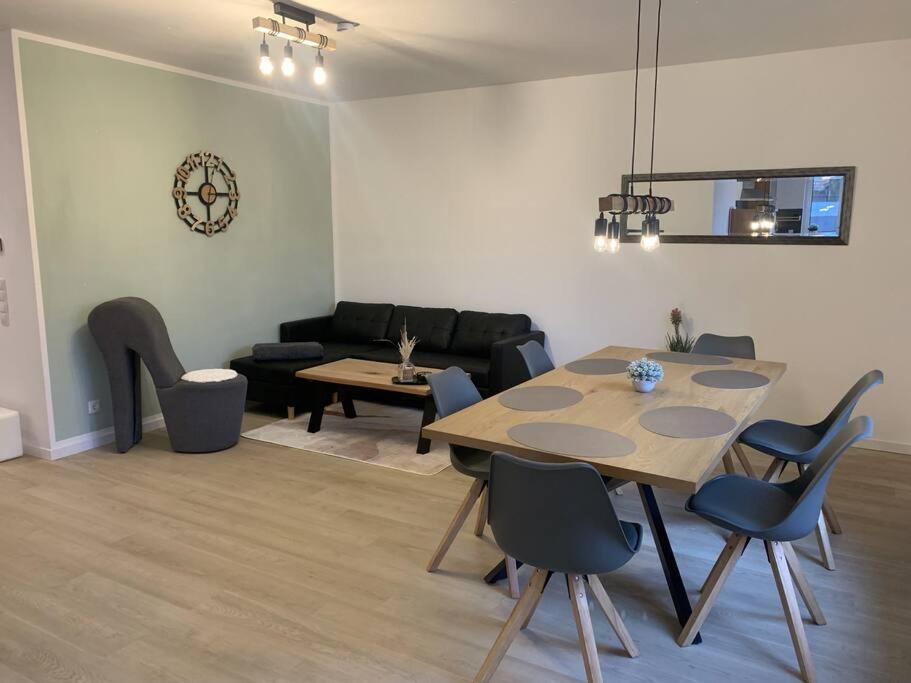 een woonkamer met een tafel en stoelen en een bank bij Neu! Modern am Bowlingcenter in Werlte