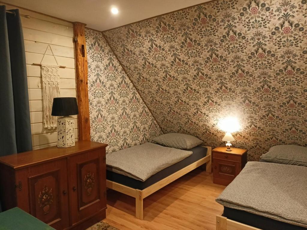sypialnia z 2 łóżkami i lampką na stole w obiekcie Świerkowe Siedlisko pokoje gościnne w Węgorzewie