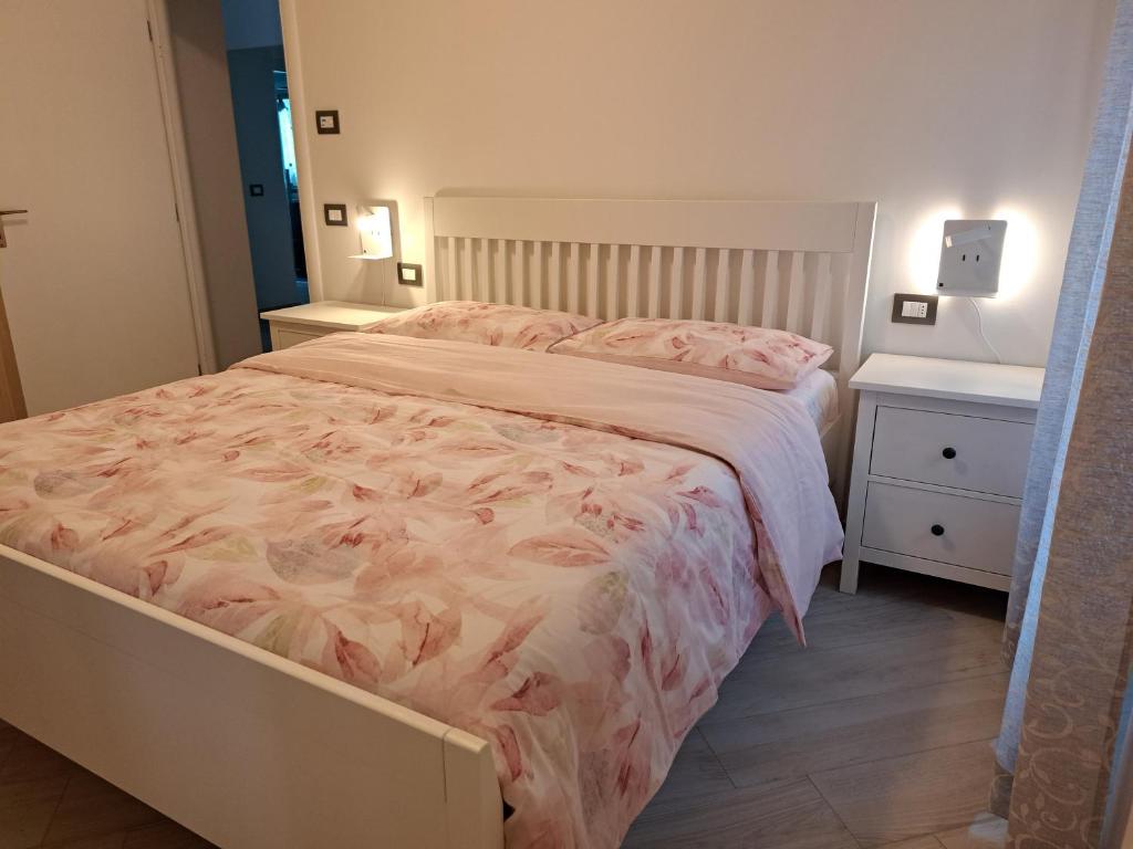 um quarto com uma cama grande e duas mesas de cabeceira em Appartamento Anto vicino al lago ai servizi al centro em Levico Terme