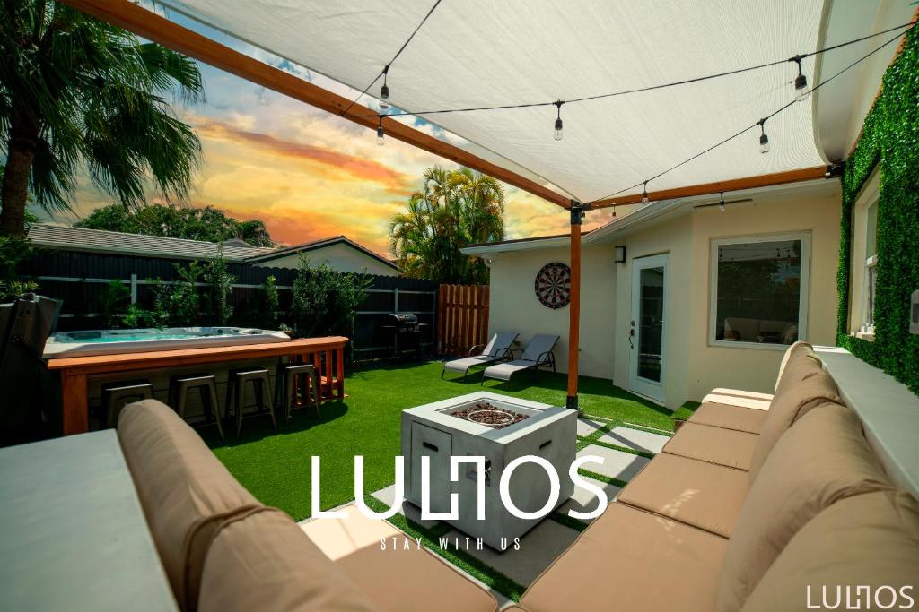een achtertuin met een bank en een patio met een hot tub bij Miami Chic 6BR Jacuzzi Games, 16 Min to Airport L52 in Tamiami