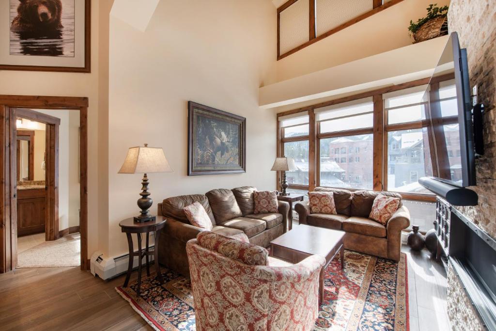 ein Wohnzimmer mit 2 Sofas und einem Kamin in der Unterkunft Exquisite Zephyr Mountain Lodge condo with 2 king en suite's condo in Winter Park